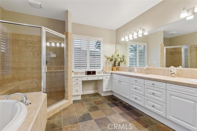 main bathroom w/soaking tub, separate shower, and two sinks, and additional vanity sitting counter w/additional storage.