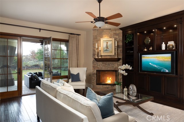 Family room with custom builtins, fireplace and open to covered patio area.