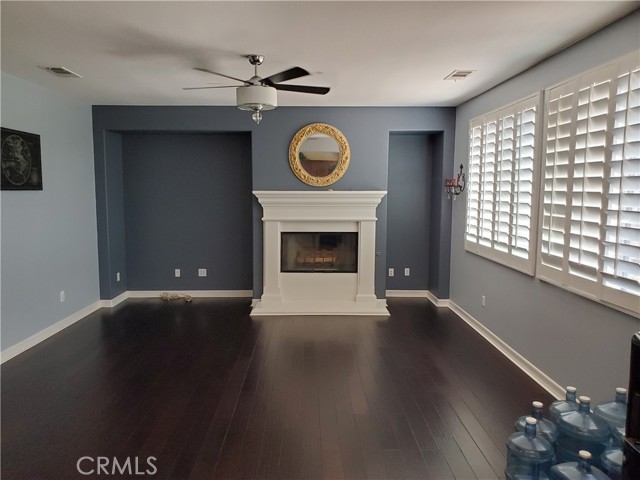 Spacious family room with custom paint, shutters, beautiful laminate floors and gas fireplace.