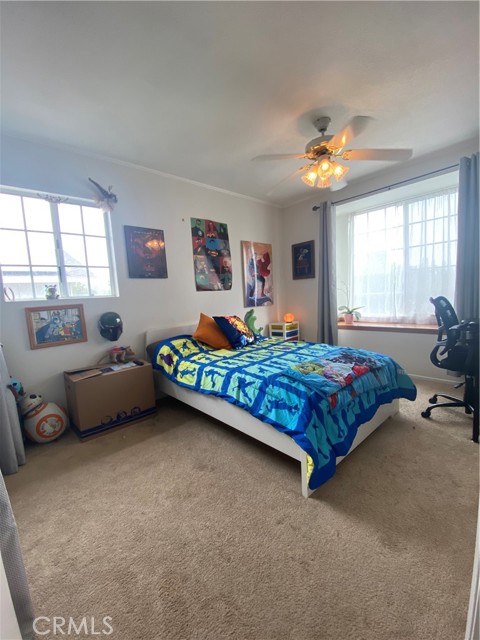 Bedroom #3 with large built in window seat, ceiling fan and crown moulding