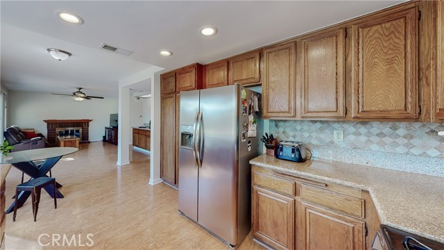 Kitchen open to eating area and family room with fireplace.