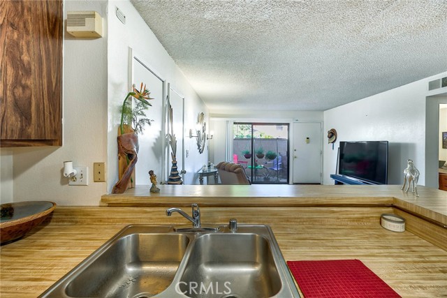 Stainless steel sink in kitchen and bar seating area.