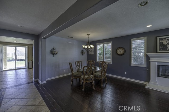 Beautiful dining area with chandelier on dimmer, plantation shutters and warm wood flooring