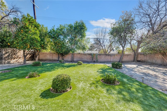 The private backyard will be a favorite entertainment destination with its expansive covered patio, landscaped grassy area, towering shade and citrus trees, paved side yard and additional space for a garden.