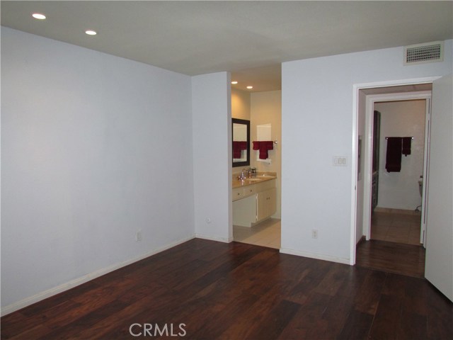 Master bedroom with view towards dressing area vanity and second closet area, entry door to right.