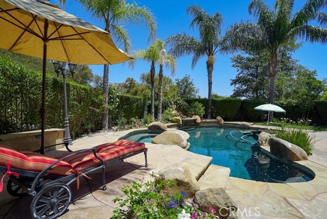 26067 Shadow Rock Lane Valencia, California A Home you will LOVE to live in! This stunning 5 bedroom, 5-bathroom Mediterranean-Style home will surely make your everyday amazing! Situated on a peaceful private lot with 4,326 Sq feet of spacious and elegant living space and manicured greenery. Constructed over two levels, this home enjoys abundant natural light and a thoughtful layout designed for easy living.
The ground floor incorporates a large open-spaced living room, a welcoming family room, and dining room, first-floor bedroom with en-suite, guest bathroom, large loft/TV room, library/office, upgraded kitchen with granite center island, and walk-in pantry. The family room’s fireplace provides comfort and warmth in the cold months while the quaint front courtyard brings warmth all year-round. On the top floor, you will find a dreamy main bedroom with an en-suite bathroom and expansive walk-in closet, private shower area, and deep tub. Additionally, three spacious secondary bedrooms, with a sizeable Jack & Jill Bathroom. featuring a balcony off of one of the bedrooms.
Beyond the sliding glass door, is the gorgeous backyard. Relax by the glistening blue pool along with the calming sounds of the waterfall or chill and eat with those closest to you by the BBQ area on the weekends. Other highlights of the home include hardwood service-like floors, central air, plentiful closet, and storage space. 3 car garage, laundry room, and service area. New Award-Winning schools, transport, shops, dining & HOA leisure amenities including Pool/Spa, Clubhouse, Tennis Courts, and much more within easy reach. What are you waiting for? Don't Delay, Call Today!