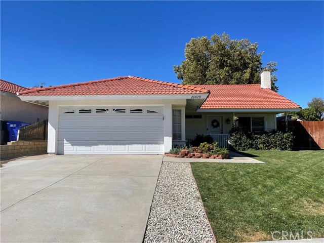 28029 Nantucket Street Castaic, California Welcome home to this charming two bed, two bath single story home sitting on a peaceful corner lot in the Live Oak community of Castaic! Fantastic starter home with lush front lawn, attached two car garage, and nice porch gate securing your entrance to the front door. Upon entry you're greeted by the living room's high cathedral ceilings and wood-like floors where you can cozy up by the white brick fireplace set against a beautiful wood paneled wall. The farmhouse style barn door serves as a great focal point separating the hallway to the bedrooms. The adjacent eat-in kitchen features French patio doors for backyard access. Both ensuite bedrooms boast a large size with their own bathrooms and ceiling fans. Primary suite has its own backyard access with updated vanity and a walk-in shower. Plantation shutters and dual pane windows throughout. Laundry closet located in hallway to bedrooms. Walking distance to Live Oak park! Great location close to the 5 freeway and multiple shopping plazas. No HOA or Mello-Roos. USDA loan eligible! Come secure this gem before it's too late!
