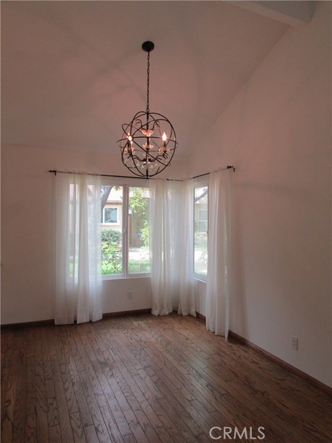 Large dining area with vaulted ceiling, custom light fixture and serene garden views.