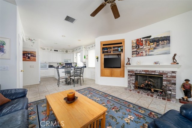 Cozy family room with fireplace, tile floors and ceiling fan