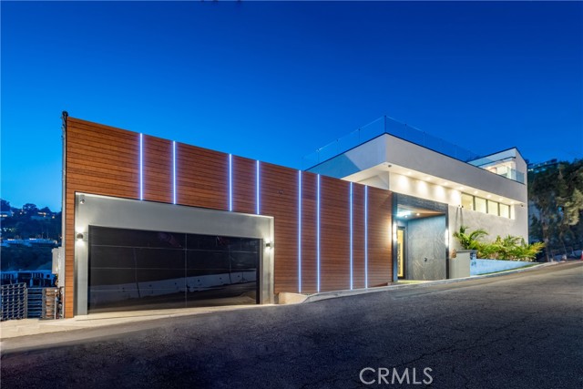 1911 Sunset Plaza Drive Los Angeles, California This new construction contemporary masterpiece offers breathtaking views of the hills and city lights and idyllic indoor-outdoor living. Past the illuminated facade and stone entryway, step into a welcoming foyer to be greeted by views. Cutting edge designer finishes take the spotlight and light pours in from double-height windows. Enjoy an office, gym, recreation room, theater, commercial-grade elevator, and 16-foot ceilings. A designer kitchen includes a center island, high-end appliances, European cabinetry, and a state-of-the-art wine display, opening to a great room. Large glass doors reveal spacious balconies. Majestic primary suite offers an impressive walk-in closet, private balcony and spa-like bathroom with solid marble tub, dual vanities, smart Mirror, and large steam shower. The rooftop deck features a resistance pool/Jacuzzi, firepit, and a bathroom. A backup power generator, garage, Savant smart home automation system, and proximity to the Sunset Strip and Gardner Street Elementary provide convenience. This luxe residence is the ultimate Hollywood Hills haven.