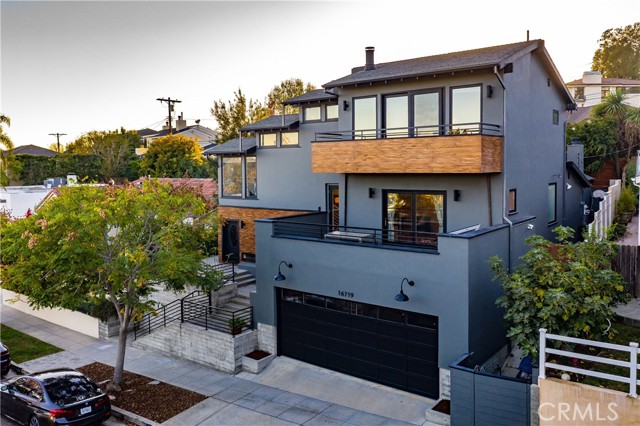 16719 Bollinger Drive Pacific Palisades, California Welcome home to one of the most coveted streets in the Palisades located in the sought-after Bollinger Loop. Easily stroll down wide sidewalks, framed w mature trees & grass, enjoy a true sense of community. This modern home floods w natural light & warmth in every room, abundance of picture windows & skylights. Striking curb w gated entry offers over 3,000 sq.ft w all the splash. Walk on gorgeous hardwood floors throughout. Concrete plank walls lead you to main level open floorplan featuring a formal living room w floor to ceiling stack stone fireplace, private office, guest room & full bath. Modern European inspired kitchen w built in eating area, S/S appliances, double oven & custom counters all flowing to the huge family room w second fireplace & access to back yard – easy indoor/outdoor entertaining. Upstairs delight in your glass work out alcove. Find a spacious 3rd bedroom w private bath & enormous balcony w mountain views. Top floor grand en-suite bedroom w high ceilings, fireplace & large step out balcony w amazing treetop & peek-a-boo ocean views. Luxury bathroom, double vanity, separate stall shower & soaking tub accented w Carrera marble. Huge 2 car garage w high ceilings & direct access into your new home. Backyard sanctuary affords plenty of room for year-round parties, playing, pets & dining including built-in BBQ all on rare pool sized yard. Close to LA’s finest beaches, Palisades Village & prestigious award-winning schools! Truly the best of the Palisades