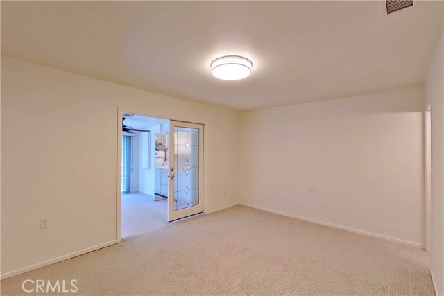 Primary bedroom, with doors leading to bonus room/enclosed patio