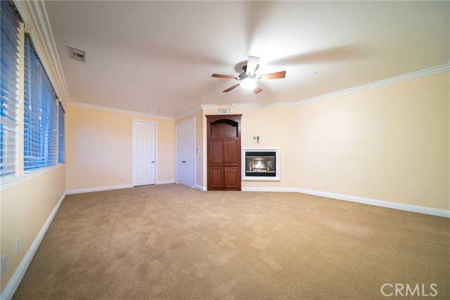 Primary Bedroom with a Fire Place and a built in Cabinetry for Media.