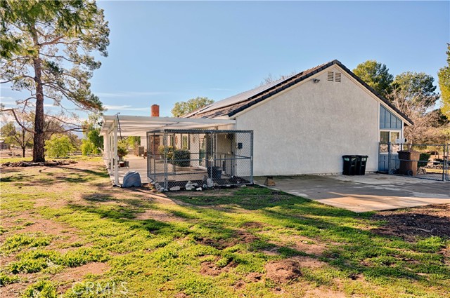 side of the house with parking pad and dog kennel