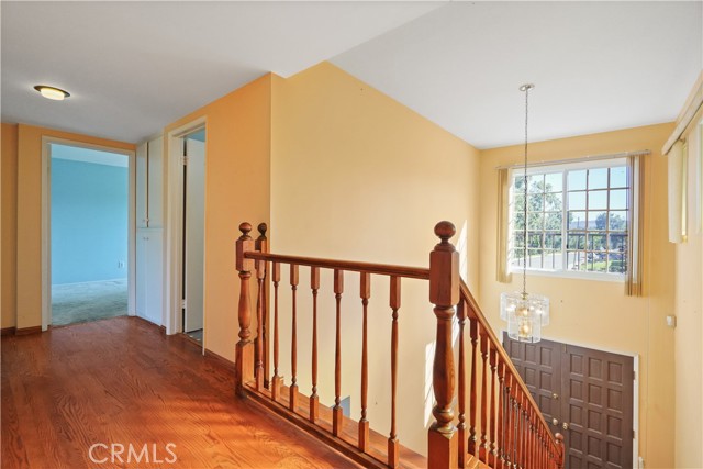 Upstairs landing with beautiful view out of the window. The second primary suite with attached bathroom is at the end of the hall