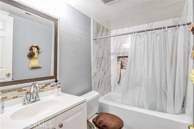 Bathroom with shower and wall shelf.