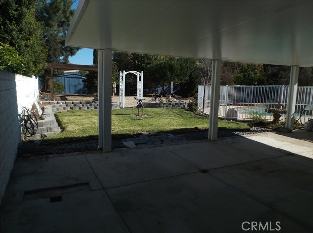 View of left side of back yard with pool to right.