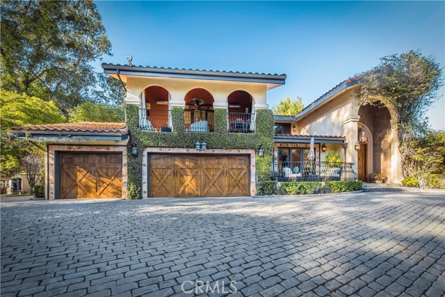 Nestled in Chevy Chase Canyon, resides this custom-built Mediterranean estate full of old-world charm. The exterior of the home is covered in ivy and surrounded by lush mature landscaping that gives a true feeling of privacy. Stately double doors invite you inside, where you’re greeted by a grand foyer with lofty ceilings. On the main level you will find a spacious dining room and living room, each boasting vaulted ceilings, as well as a gourmet kitchen that includes top-of-the-line appliances, a breakfast nook and large island with a breakfast counter. The primary suite features a large walk-in closet and opulent bath with a jetted tub and double vanity. Upstairs there are three bedrooms, one of which is an ensuite, and a family room that has an inviting covered balcony. French doors located in the living room, kitchen and primary suite open directly to the expansive patio where you can enjoy al fresco dining next to a cozy wood burning fireplace. The serene backyard sanctuary also features a resort-like pool/spa, cabana with summer kitchen/bar and lower deck nestled amongst mature trees. Additional amenities include a three car garage and large gated motor court. Conveniently located walking distance to Chevy Chase Golf Club.