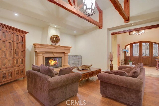 Living room with hardwood floor, hand distressed beams and a great fireplace