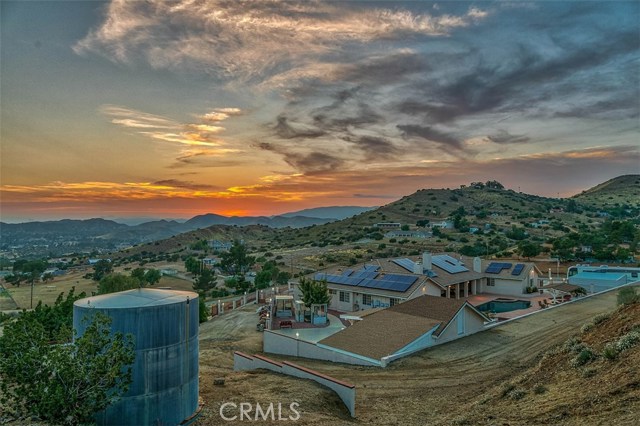 33650 Tataviam Drive Agua Dulce, California Incredible single story estate! Gorgeous mountain views for miles! Open floor plan, cathedral ceilings & dual master bedrooms w/ fireplace in each. 8" tile flooring w/ carpet in bedrooms; Kitchen has GE Profile Subzero built-in refrigerator, stainless steel dishwasher, microwave, 3 ovens, granite counter tops & maple cabinets; Upgraded crown molding throughout; Recessed lighting; Fireplace in living room; Dual zone A/Cs; Tank-less water heaters; Spacious laundry room w/sink; Bathtubs in all bathrooms w/ jetted tubs in both masters; Ceiling fans in every room; Central vacuum and Solar! Home has wrought iron fencing & automatic gated entry, along w/chain link fencing around the land; 360-degree road access to residence; Driveway paved; All weather private road; Complete RV set up w/ dump station; 4 car finished garage, large enough to fit a 28' boat (approx. 26'x40') w/new 8' doors; 4 car metal carport; Perimeter lights w/ surge protector; Entertainers backyard w/ large covered patio (approx. 15'x55'), built in BBQ, beautiful pool and spa, stamped, colored concrete surrounding pool; 100 year tile roof; Over-sized water tank w/ attached fire hydrant; Interior sprinkler system; Alarm systems; Large 2-story approx. 20'x20' storage shed; Free standing finished approx. 20'x20' Tuff shed wired for A/C. Upgraded well equipment incl plumbing; Enclosed pump & well houses; 10 stage water irrigation system. Meticulously kept! Be sure to check out the 3-D tour & aerial video.
