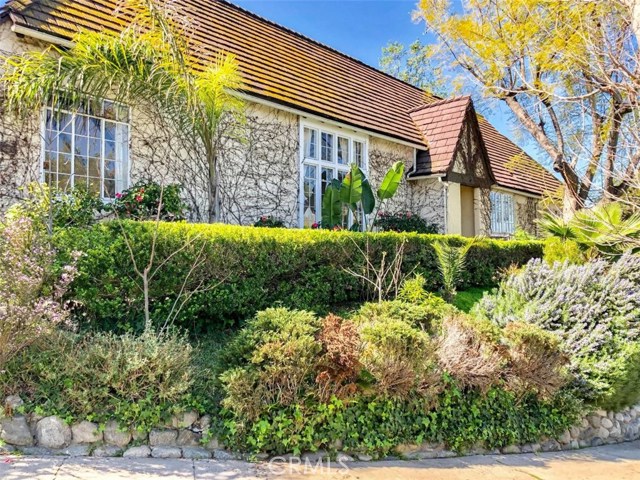 1145 S Longwood Avenue Los Angeles, California The comfy and unfurnished interior features quaint shed/exposed beam ceilings, polished hardwood flooring, recessed/suspended lighting, fireplace, walk-in closet, and big windows with blinds that let in natural light and fresh air to enter the rooms. A stunning galley-type kitchen is equipped with smooth counter tops, fine dark-toned wooden cabinets and drawers with ample storage space, and ready-to-use appliances such as refrigerator, garbage disposal, microwave, oven/range with hood, and dishwasher. There are hookups for washer and dryer. Shower/tub combos, pedestal sink, and vanity cabinets with framed mirrors furnished the bathrooms. For climate control, it has installed air conditioning and forced-air heating. The exterior features a yard surrounded by well-manicured shrubbery, flower-bearing plants, and trees. The tenant must maintain the yard’s upkeep.
The