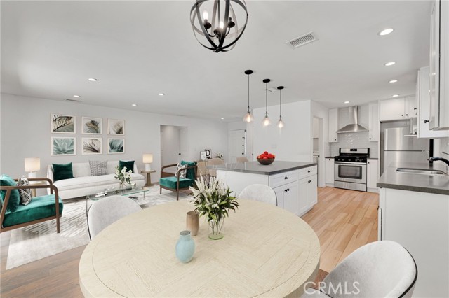 The living room is bathed in natural light and is enhanced by recessed lights, modern wood flooring and sliding glass doors that lead to the backyard.  (Photo is virtually staged to create a visual landscape of all this property has to offer.)