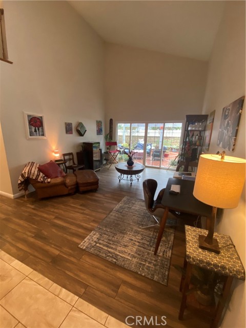 Large Secondary living room area with ample natural light, access to back yard, cathedral ceilings, recessed lighting, skylight and updated floors