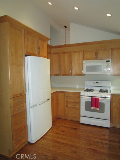 Left side of kitchen with included Samsung refrigerator, GE self cleaning stove and built in microwave hood. Lazy Susan corner cabinet as well.