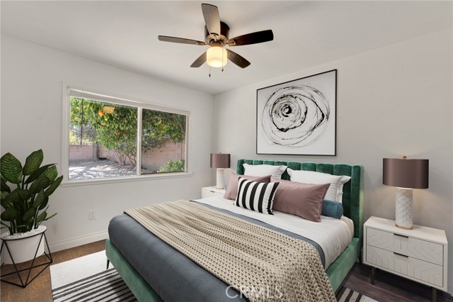 The primary suite is enriched by a picture window, lighted ceiling fan, ample closet space, and complementary modern wood floors. Two additional bright and airy bedrooms with picture windows, ample closet space to maximize storage and wood flooring.  (Photo is virtually staged to create a visual landscape of all this property has to offer.)