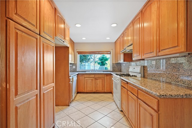 The window over the sink looks out at the pool and the view looking north. pantry closet on the right. Granite counters.