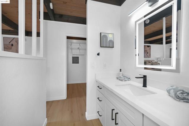 Bathroom featuring vanity, light wood-style floors, and a wood ceiling with exposed beams