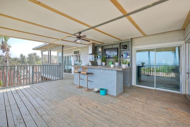 Large covered patio with cooking area and tiled counter.