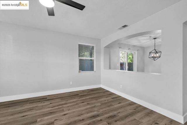 Empty room featuring wood finished floors and a chandelier