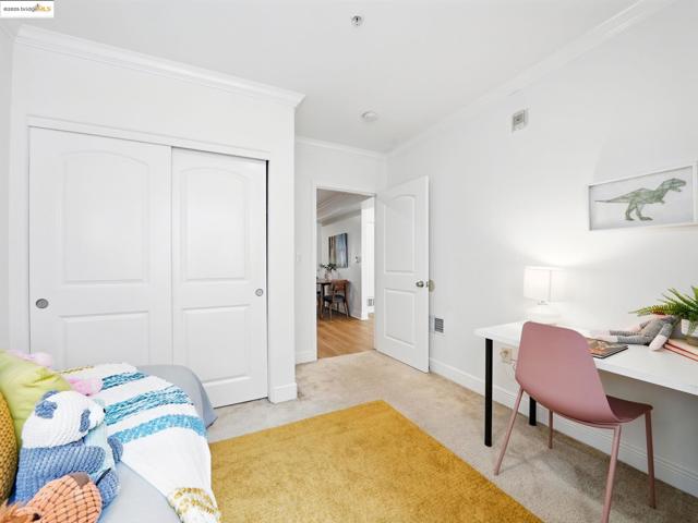 Bedroom with light carpet, ornamental molding, a closet, and a desk
