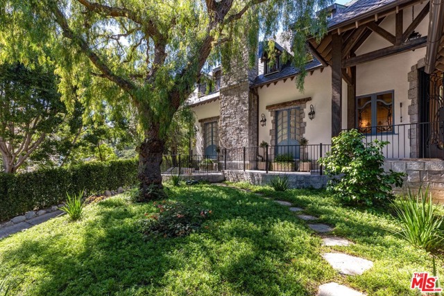 1455 Lindacrest Drive Beverly Hills, California Sophisticated European farmhouse behind gates in Prime BHPO. Recently remodeled with extraordinary attention to detail all while keeping the original charm. Warm and graceful family home with 5 en- suite bedrooms, 6 baths. Exquisite collection of imported ornamental beachwood chevron pattern hardwood floors, spectacular stained glass, etched glass doors and windows, along with weathered antique beams throughout the home. Family room, generous gourmet center-island kitchen with top of the line appliances all with doors and windows leading to the private yard. 2 story LR, formal DR, library, gym, complete home automation, and entertaining yard with new pool complete this masterpiece. A residence of great beauty, style and total privacy.