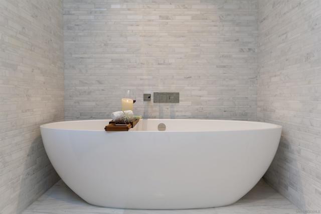 Victoria Albert bathtub with white marble tile finishes.