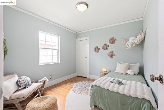 Bedroom featuring ornamental molding and wood finished floors