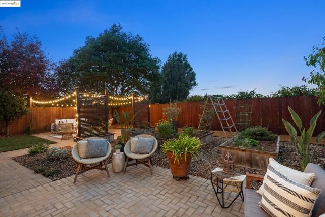 Fenced backyard with a patio, outdoor lounge area, and a garden