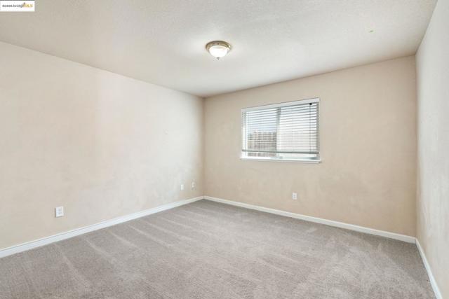 Empty room featuring light carpet and baseboards