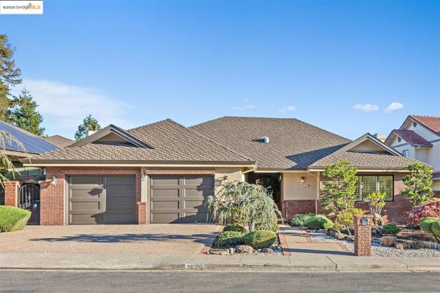 Single story home with decorative driveway, a garage, a shingled roof, stucco siding, and brick siding