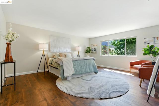 Bedroom featuring dark wood-type flooring and baseboards