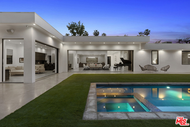 410 Evelyn Place Beverly Hills, California This stunning, private, and sophisticated single-story contemporary in the heart of Trousdale Estates boasts warm, rich interiors, walls of glass, high ceilings, and elegant floor plan. Grand entry invites you to open and comfortable living space, complete with fireplace, easy outdoor access, and automatic sliding doors. Chef's kitchen features high end appliances and separate butler's pantry. Sumptuous and spacious master suite is complete with inviting fireplace, lounge area, luxurious walk-in closet, and direct access to yard and pool. Secondary living room sits among the guest bedrooms, all of which have en-suite bathrooms. Backyard is exceedingly private, featuring grassy pad, pristine, pool, and bar. Located in close proximity to Beverly Hills shops and restaurants.