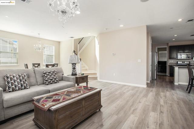 Living room featuring a chandelier, light wood finished floors, stairs, and recessed lighting