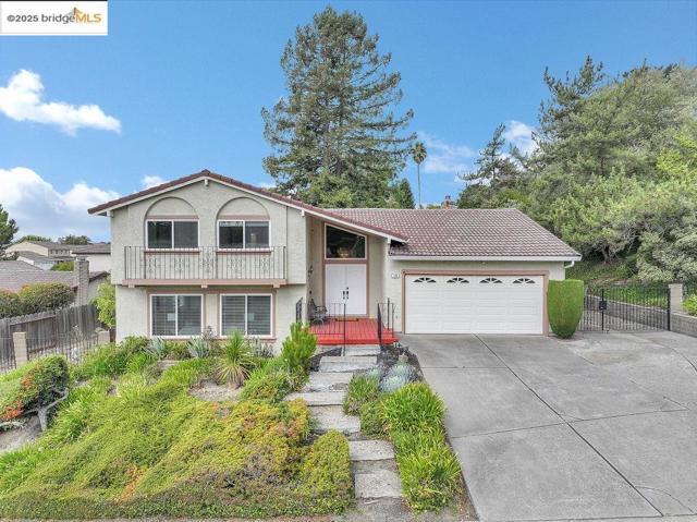 View of front of home featuring stucco siding, concrete driveway, an attached garage, and a tiled roof