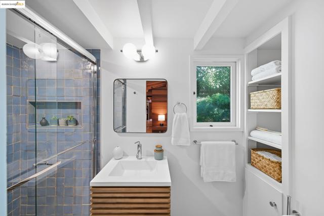 Bathroom featuring vanity, a stall shower, and beam ceiling