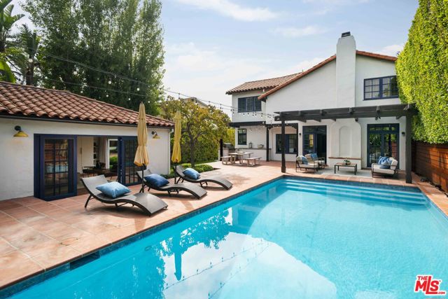 Set on a large lot in the coveted El Medio Bluffs neighborhood of Pacific Palisades, this charming Spanish residence features the character of an original 1920s Spanish, such as a two-story entry, wood-beamed ceilings, arched hallways, hardwood floors, terra cotta roof tiles, handcrafted tile/ironwork, and more, yet offers the modern amenities and design of a recently-built home. Through a grassy front yard, guests are welcomed into the light-filled foyer flanked by the formal living room with fireplace and dining room. Through the hallway past a large office and powder room is the open layout family room with fireplace, breakfast area, butler's pantry, and redone kitchen with island - all flowing out to the incredible backyard. Upstairs are three large bedrooms, including the impressive primary suite with a walk-in closet, and a spa-like bathroom with an oversized shower, spa tub, and dual vanities, as well as two bathrooms, a laundry room, and built-ins. A movie-like setting under string lights and high hedges, the private backyard may be one of the best in the neighborhood. Features include a newer pool, firepit, al fresco dining under a beautiful trellis, built-in BBQ, grassy yard, and a kids' play area. The casita/poolhouse boasts accordion doors from the main area, a bedroom, and a bathroom. The offering is completed by two-zone HVAC, house/yard surround sound, EV charger, and electric pool cover. Located on an idyllic tree-lined street less than a mile from the famed Palisades Village and just minutes from the beach, this is an opportunity not to be missed.