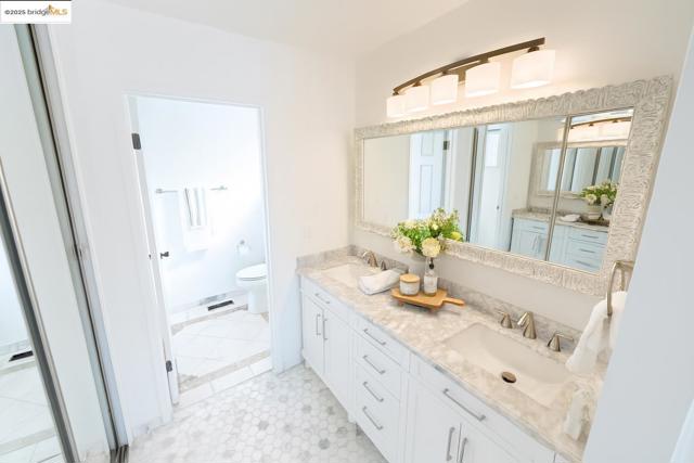 Full bathroom featuring toilet and double vanity