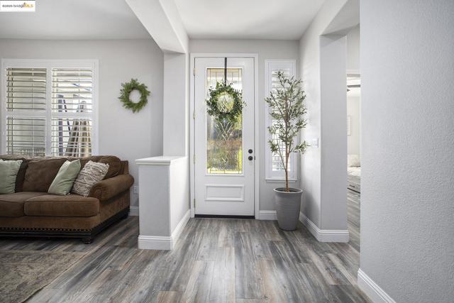Foyer with laminate wood-style finished floors and a textured wall