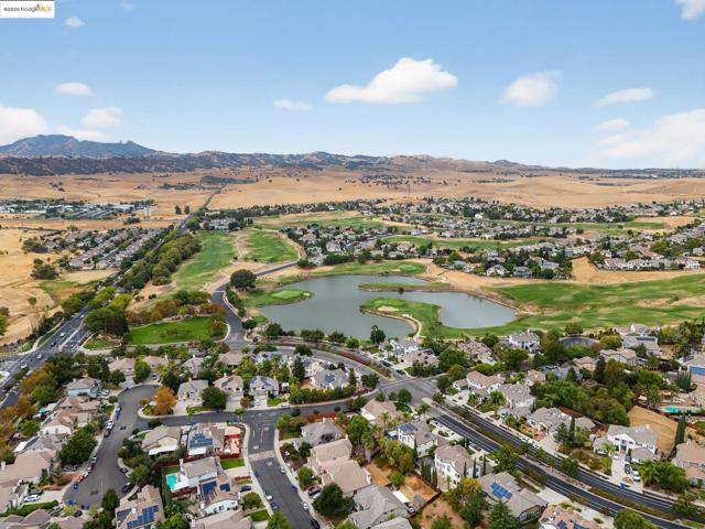 View of property location with nearby suburban area, a water and mountain view, and a local golf course