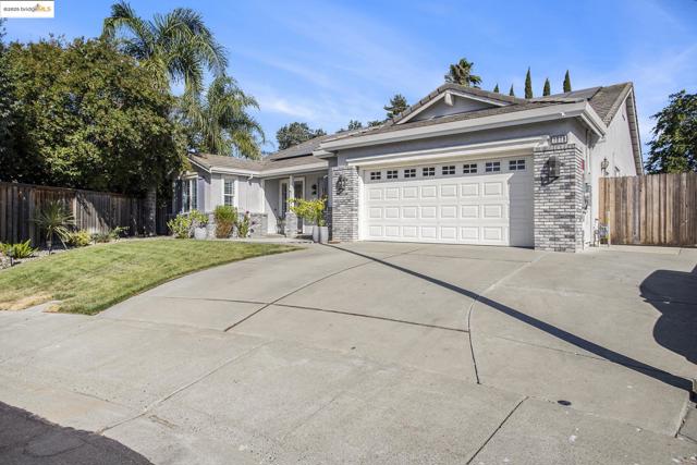 Traditional ranch-style home with RV access, stucco siding with brick exterior finish.